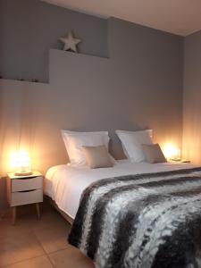 LensPanda Parc Appartment proche Pairi Daiza-Shape-Nato的一间卧室配有一张带两盏灯的大型白色床。