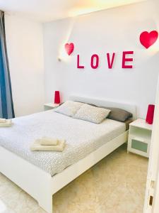 科斯塔特吉塞New Canela Apartment的卧室配有一张挂有爱情标志的床