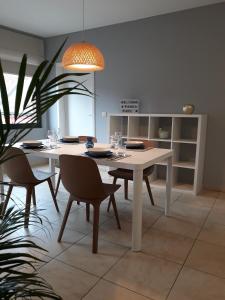 LensPanda Parc Appartment proche Pairi Daiza-Shape-Nato的一间配备有白色桌椅的用餐室