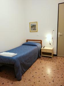 东塞斯特里叙伊斯酒店的一间卧室配有蓝色的床和床头柜