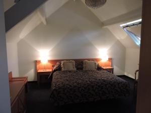 LauweManoir thoveke的卧室配有一张床,墙上有两盏灯