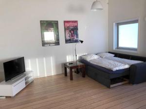 努克Kang Apartment的一间卧室配有一张床和一台平面电视