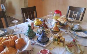 马拉喀什Maison Zaitouna的一张桌子,上面有羊角面包和五颜六色的花瓶