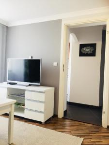 普什奇纳Apartament Na Starówce VII的一间客厅,客厅内配有白色梳妆台上的电视