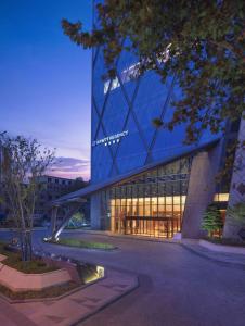 镇江镇江凯悦酒店 的一座在晚上拥有玻璃幕墙的大建筑