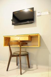 阿罗士打HOTEL MESRA ALOR SETAR的一张桌子、椅子和墙上的电视