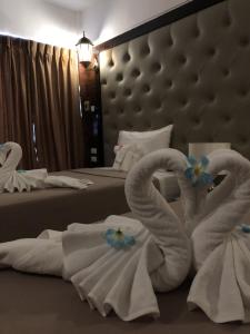 Ban Bang BamruSUDYOD HOTEL的两间天鹅折叠毛巾(放在酒店客房内的床上)