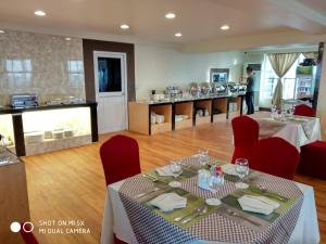 仰光银绿色酒店的餐厅设有桌子和红色椅子,提供自助餐