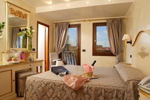 威尼斯卡尔顿卡普里酒店的一间卧室配有一张带桌子和台面的床