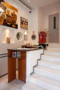 雅典大都市酒店的客房设有楼梯和带桌子的柜台。