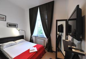 敖德萨里诺酒店的一间卧室配有一张带红色毯子的床和窗户。