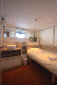 阿姆斯特丹卡皮腾安娜旅馆的客房设有两张床、一个水槽和镜子