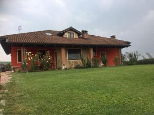 福萨诺Il Bambuseto的前面有绿色草坪的红色房子