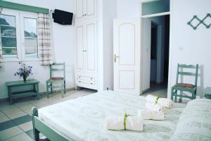 阿齐亚马利那Tassos Apartments II的一间白色卧室,配有一张床和两把椅子