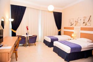 阿布扎比Platinum Hotel Apartments的酒店客房设有两张床和电视。
