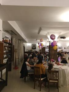 拉姆尼库沃尔恰Hotel Casa Vlahilor的一群坐在餐厅桌子上的人