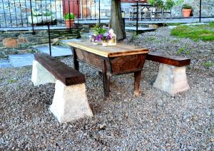 RonApartamentos Rurales RON的一张木桌和一张布满鲜花的长凳