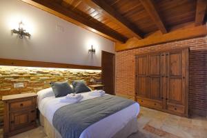 科卡Señorío de los Fonseca的一间卧室设有一张大床和砖墙