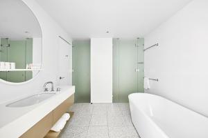布里斯班艺术系列酒店 - 约翰逊的白色的浴室设有浴缸和水槽。