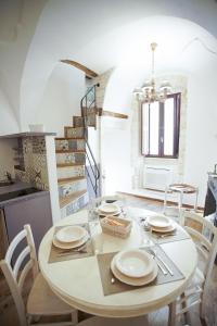 普蒂尼亚诺Dimora Maestà的一间带桌椅和楼梯的用餐室