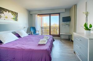 达克斯埃斯佩斯温泉公寓酒店的卧室配有紫色床和阳台