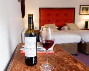 奇平卡姆登诺埃尔阿姆 - “订制酒店”的一瓶红酒和一张桌子上的一杯