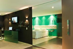 累西腓Forum Motel的卧室配有白色的床和绿色的墙壁