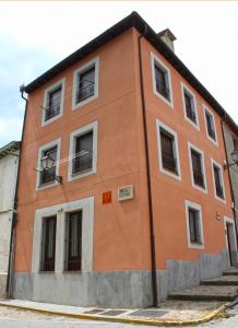 拉·格兰哈·圣·伊尔德Casa del Plantel的一座橙色的建筑,街上有窗户