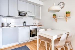 坦佩雷Haave Apartments Tampere的白色的厨房配有白色的桌子和椅子