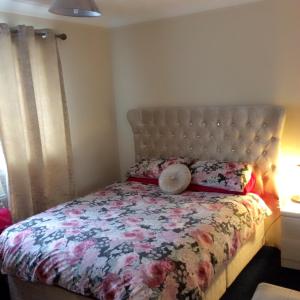 Grain山林小屋旅馆的一间卧室配有一张带花卉棉被的床