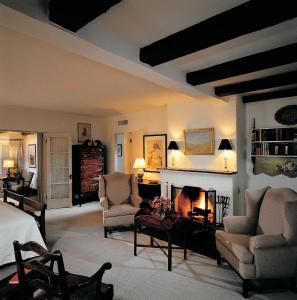 土桑亚利桑那旅馆的客厅设有壁炉、2把椅子和1张床
