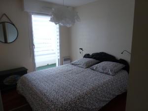 洛里昂Appartement 3 pièces coeur de ville的一间卧室配有带两个枕头的床和窗户