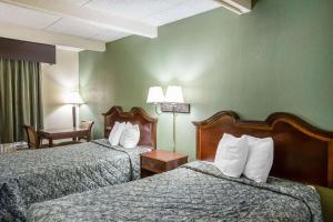 LaurensRodeway Inn的酒店客房,配有两张床、椅子和桌子