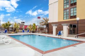 比洛克西Comfort Inn & Suites Biloxi-D'Iberville的一座带椅子的酒店游泳池以及一座建筑