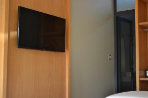 奇维尔科伊Hotel Tomaso的卧室墙上的平面电视