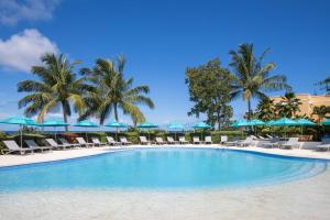 圣詹姆斯海滩景观酒店的一个带椅子和遮阳伞的游泳池以及棕榈树
