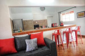 利文斯顿Butterfly Apartments的带沙发和一些红色凳子的客厅