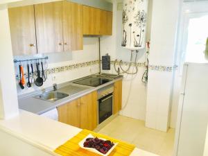 米哈斯科斯塔Apartment Aguila Real的厨房配有木制橱柜、水槽和冰箱。