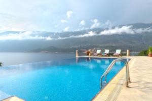 卡斯Villa Poseidon-in winter heated outdoor pool的享有水景的游泳池