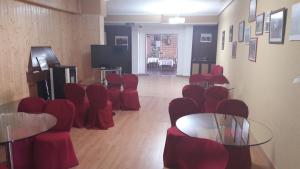 维拉雷斯迪拉雷纳卡斯蒂利亚科罗纳酒店的一间设有红色桌椅和电视的房间