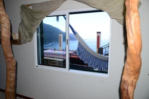 莫尼兹港Janela para o Atlântico的窗户配有吊床,俯瞰着大海
