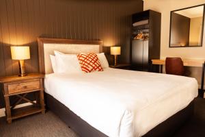 诺拉Nightcap at Archer Hotel的卧室配有一张白色大床和两盏灯。