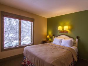 ThompsonvilleSpacious 2 Bed Condo at Crystal Mountain Resort的一间卧室配有一张带两盏灯的床和一扇窗户。
