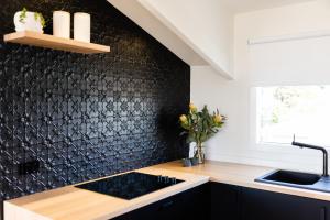 霍巴特Litora Accommodation的厨房设有水槽和黑色墙壁