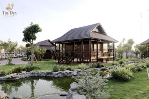 金瓯THƯ DUY Resort的一座木屋,前面设有一个池塘