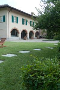 卡拉曼德拉纳La Giribaldina Winery & Farmhouse的绿色百叶窗和草地庭院的房子