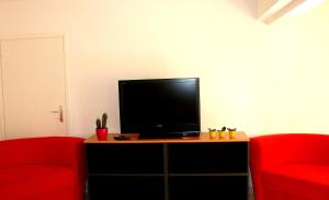 法扎纳安佛拉旅馆的客厅配有2把红色椅子和平面电视