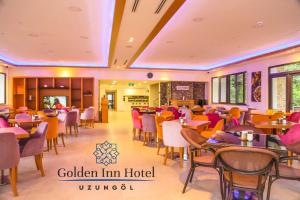 乌宗Golden Inn Hotel Uzungöl的餐厅内带桌椅的用餐室