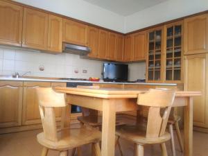 TassulloMELAX Apartment的厨房配有木制橱柜和木桌及椅子