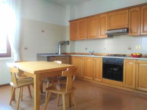 TassulloMELAX Apartment的厨房配有木制橱柜、桌子和水槽。